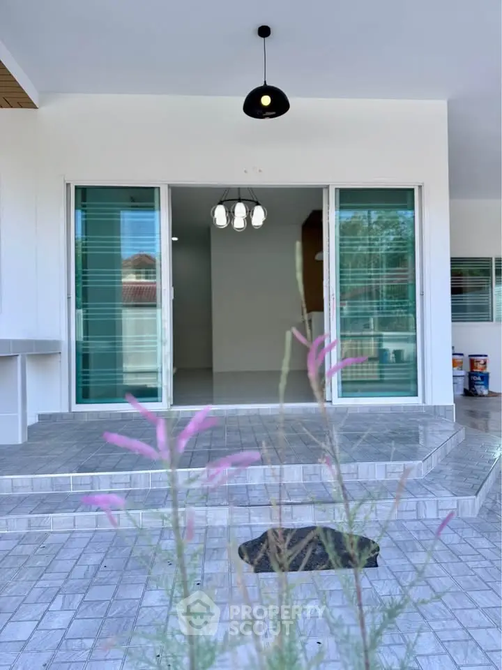 Modern home entrance with sliding glass doors and stylish lighting