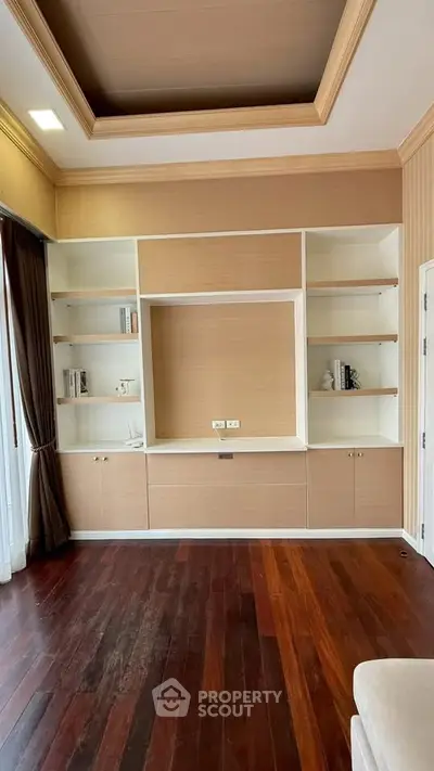 Elegant living room with built-in shelving and hardwood floors
