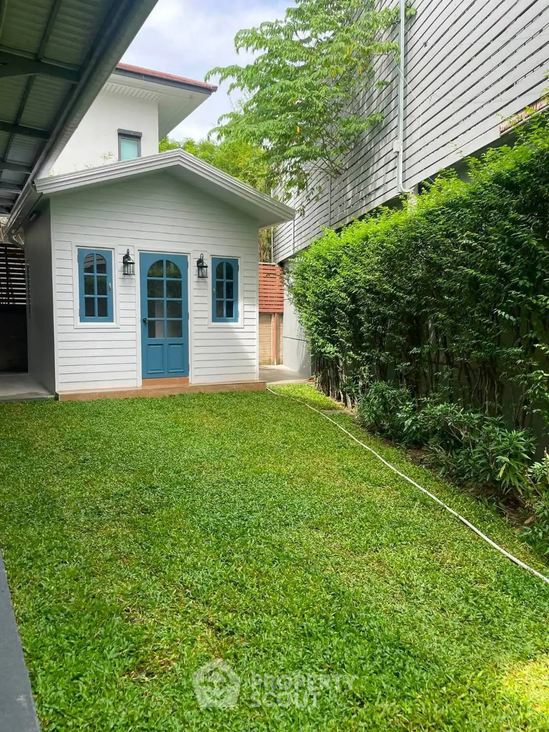 Charming backyard with lush green lawn and quaint garden shed, perfect for outdoor relaxation.