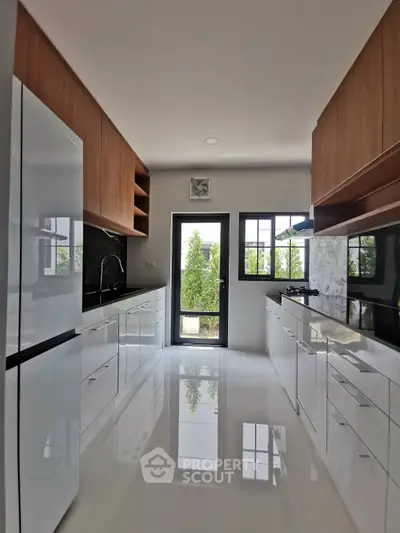 Modern kitchen with sleek cabinetry and glossy white flooring