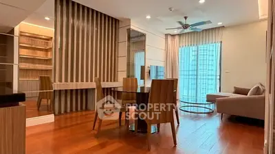 Modern living room with wooden flooring, stylish furniture, and large windows for natural light.