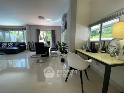 Spacious modern living room with sleek furniture and large windows offering abundant natural light.
