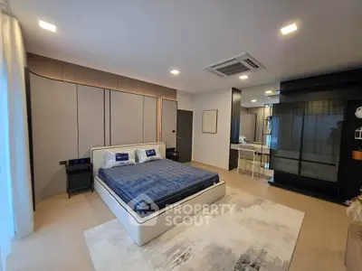 Spacious modern bedroom with stylish decor and ample natural light