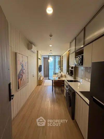 Modern apartment interior with sleek kitchen and cozy living area, featuring stylish decor and ample natural light.