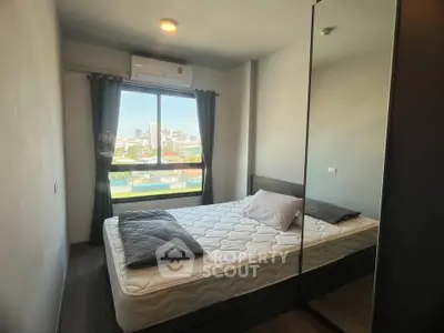 Cozy bedroom with large window offering city views, featuring a comfortable bed and modern decor.