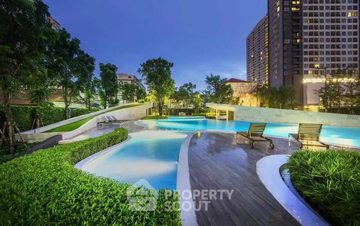 Luxurious outdoor pool area with modern design and lush greenery in urban setting.