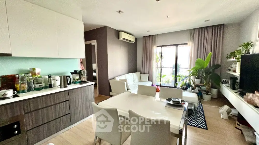 Modern open-layout living room and kitchen with stylish decor and natural light