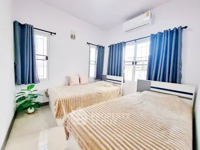 Bright and cozy bedroom with twin beds, air conditioning, and elegant blue curtains.