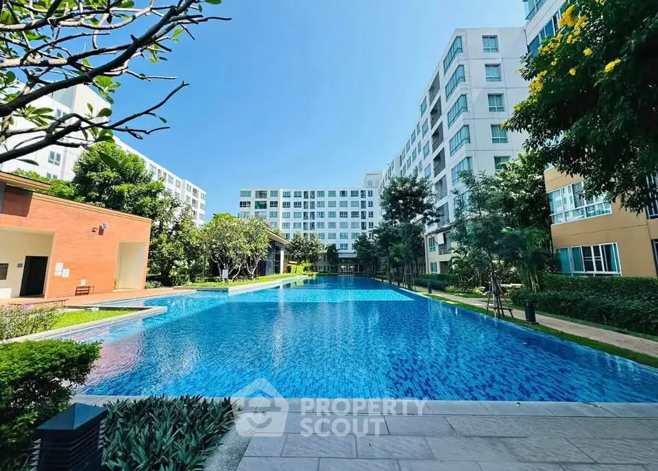 Luxurious apartment complex with stunning outdoor pool and lush greenery.