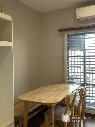 Cozy dining area with wooden table and chairs near window with blinds