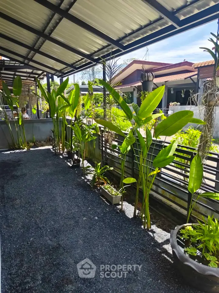 Charming outdoor garden area with lush greenery and modern fencing, perfect for relaxation and outdoor activities.