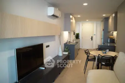 Modern living room with sleek furniture and open kitchen layout in a stylish apartment.