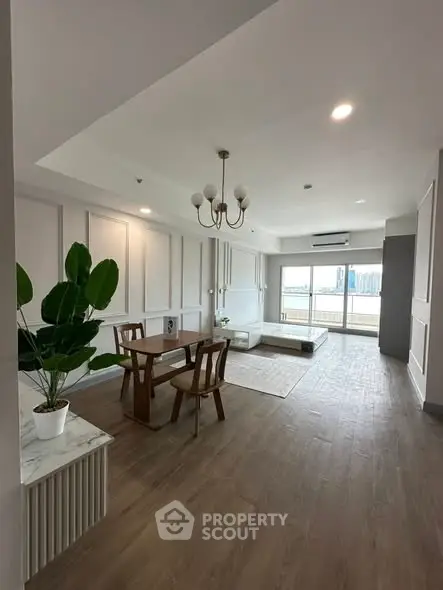 Spacious modern living room with elegant decor and large windows offering city views.