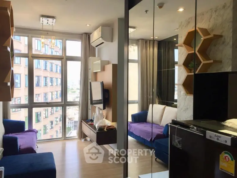 Modern living room with large windows and stylish decor in a high-rise apartment.