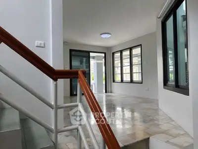 Spacious modern interior with large windows and sleek staircase, perfect for contemporary living.