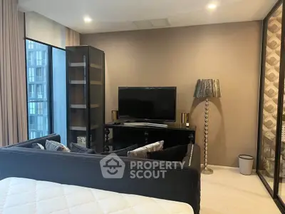 Modern living room with sleek furniture and large TV in a stylish apartment.