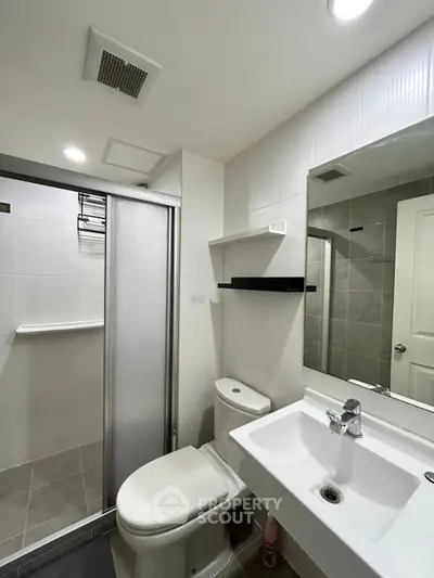 Modern bathroom with sleek shower and contemporary fixtures in stylish apartment.