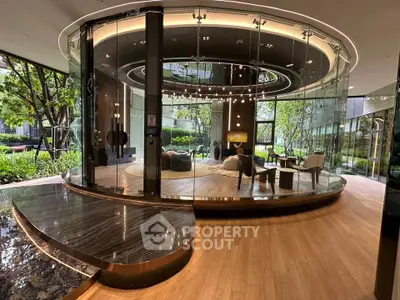 Luxurious modern lobby with circular glass design and elegant furnishings in a high-end building.