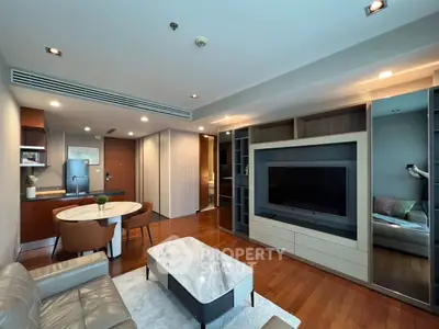 Modern living room with sleek furniture and open layout, featuring a large TV and stylish decor.