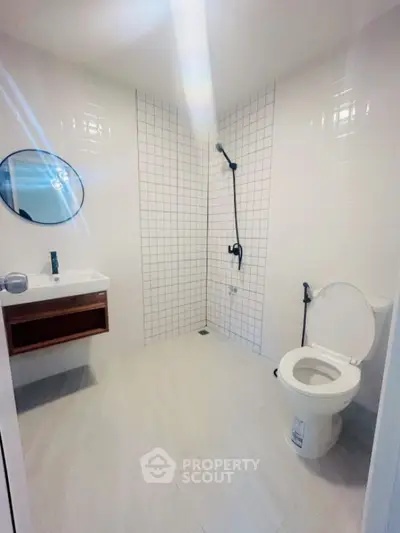 Modern minimalist bathroom with white tiles and sleek fixtures