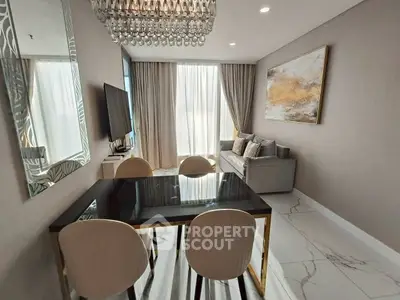 Elegant living room with modern decor, chandelier, and stylish furniture