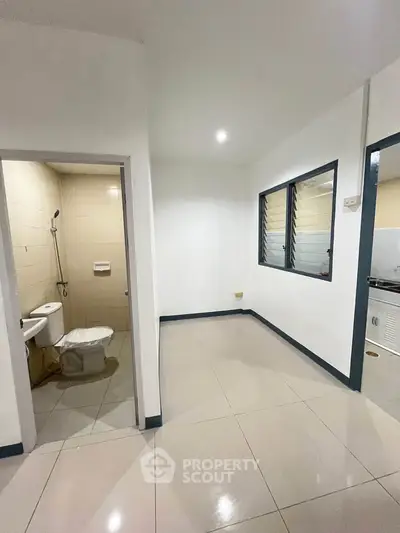 Compact apartment interior with bathroom and tiled flooring, ideal for urban living.