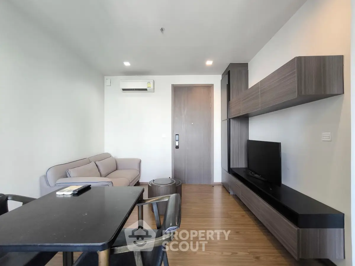 Modern living room with sleek furniture and wall-mounted TV in a stylish apartment.