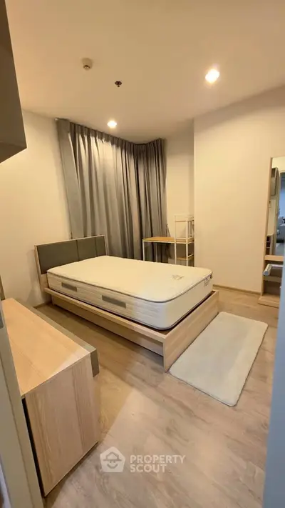 Modern bedroom with minimalist design, featuring a comfortable bed and stylish furnishings.