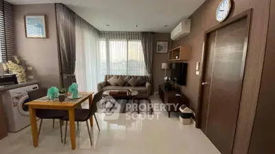 Modern living room with dining area and washing machine, featuring stylish decor and natural light.