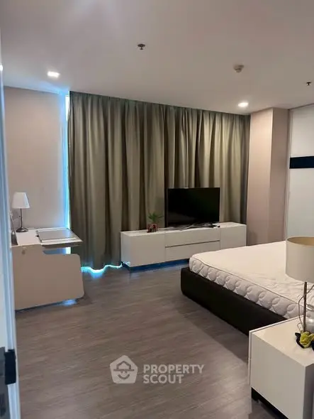 Modern bedroom with sleek furniture and large window curtains