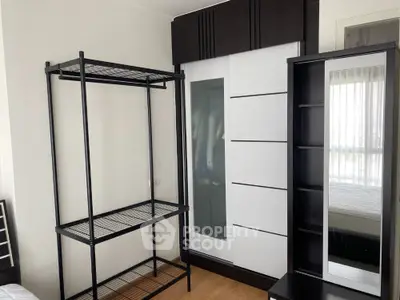 Sleek modern bedroom with ample storage, featuring a large wardrobe with mirrored doors and a stylish metal shelving unit, complemented by natural light.