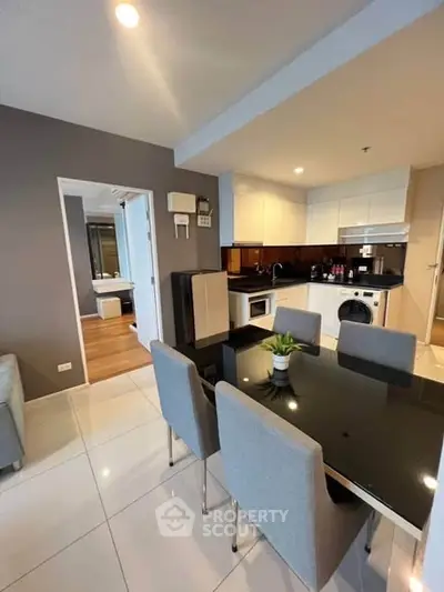 Modern open-layout kitchen and dining area with sleek appliances and stylish decor.