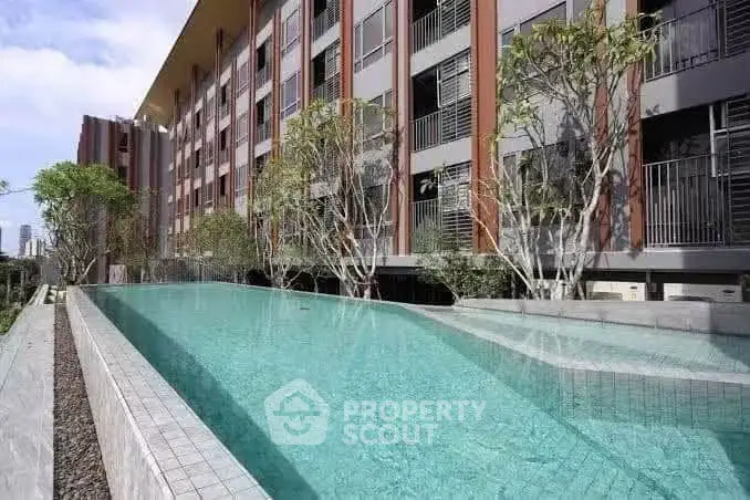 Luxurious apartment building with stunning outdoor pool and modern architecture.