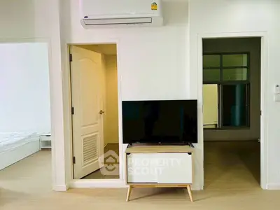 Modern apartment interior with TV and air conditioning, showcasing minimalist design.