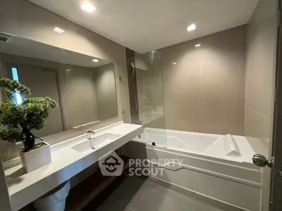 Modern bathroom with sleek design and spacious bathtub, perfect for relaxation.