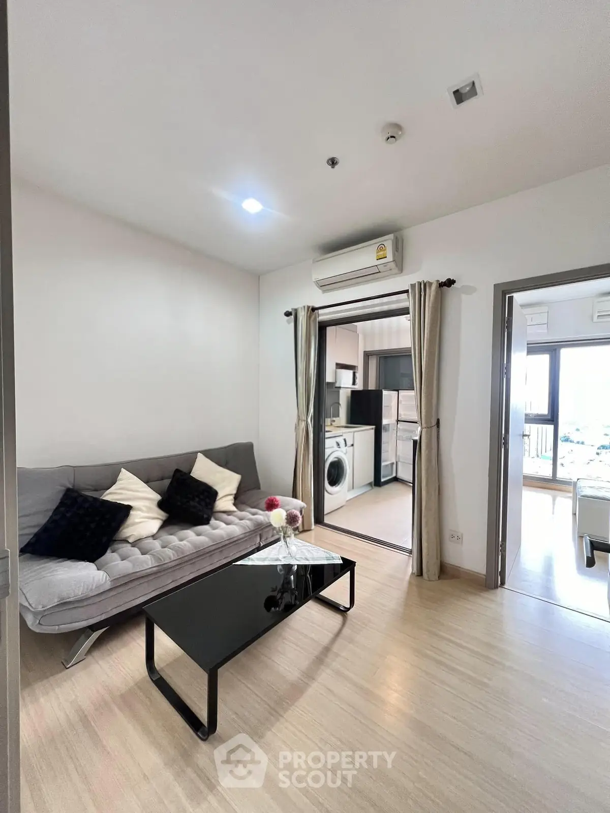 Modern living room with sleek furniture and open kitchen layout in a stylish apartment.