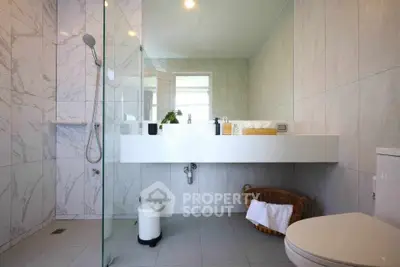 Luxurious modern bathroom with sleek design and elegant fixtures, featuring a spacious shower and stylish vanity.