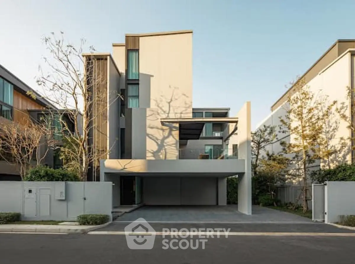 Modern multi-story residential building with sleek design and spacious driveway.