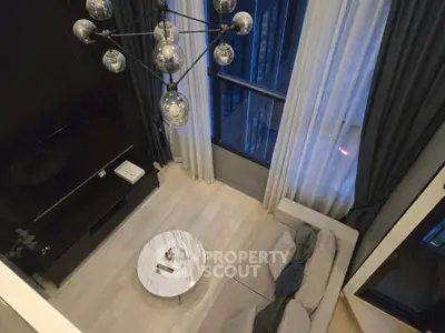 Luxurious high-ceiling living room with modern chandelier and large windows