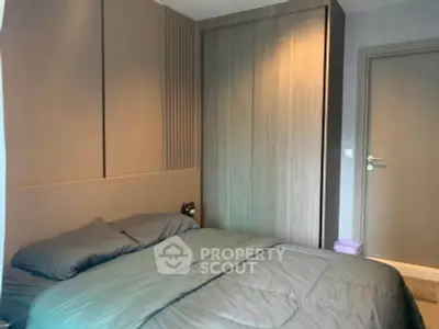 Modern bedroom with sleek design and cozy bedding in a stylish apartment.