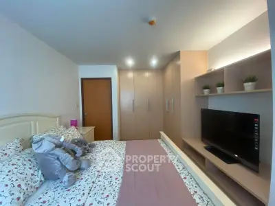 Cozy bedroom with modern wardrobe and TV, featuring plush elephant decor and floral bedding.