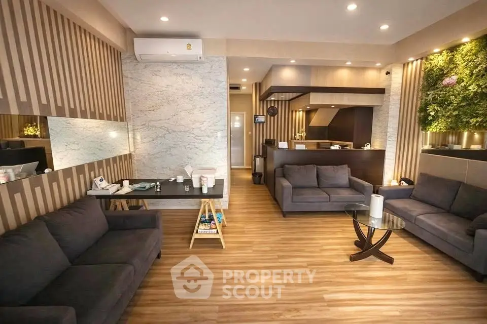 Modern living room with stylish decor and wooden flooring, featuring a cozy seating area and elegant lighting.