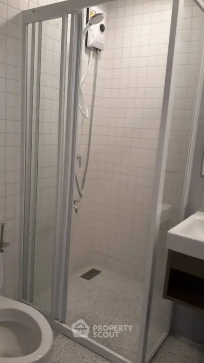 Modern bathroom with glass shower enclosure and white tiles