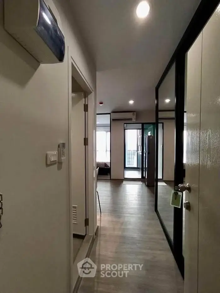 Modern apartment hallway with sleek design and wooden flooring