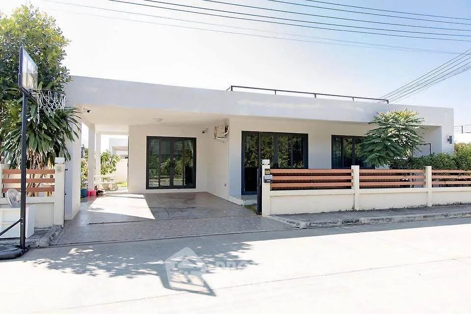 Modern single-story home with sleek design and spacious driveway
