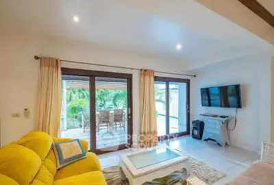 Bright living room with yellow sofa, large windows, and garden view, perfect for relaxation.