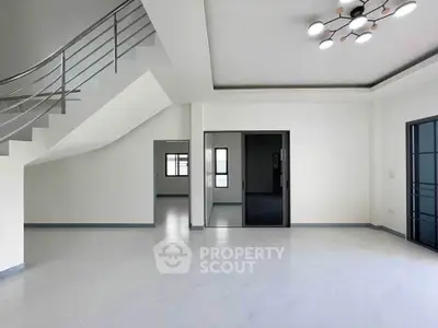 Spacious modern living room with sleek staircase and contemporary lighting