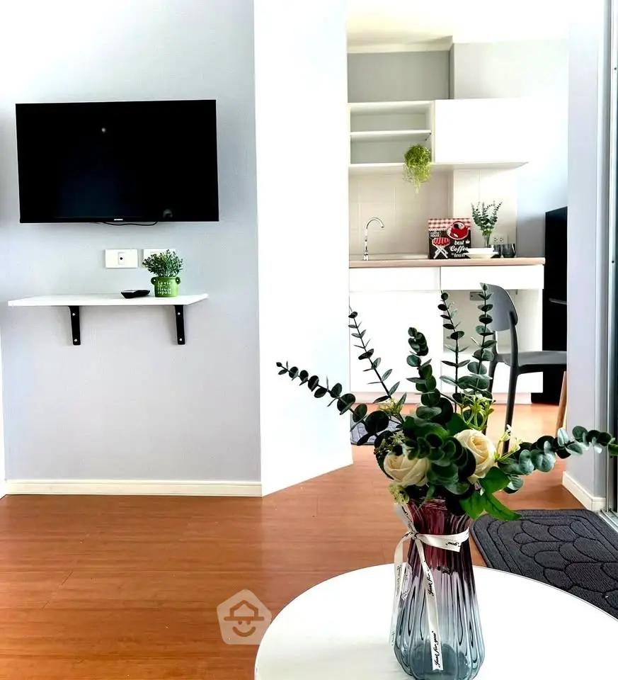 Modern living room with wall-mounted TV and stylish kitchen in open layout