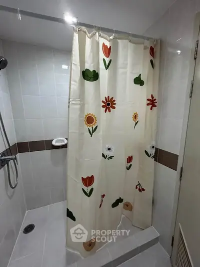 Charming bathroom with floral shower curtain and modern fixtures.