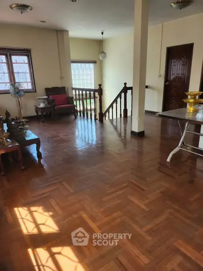 Spacious living room with wooden flooring and natural light